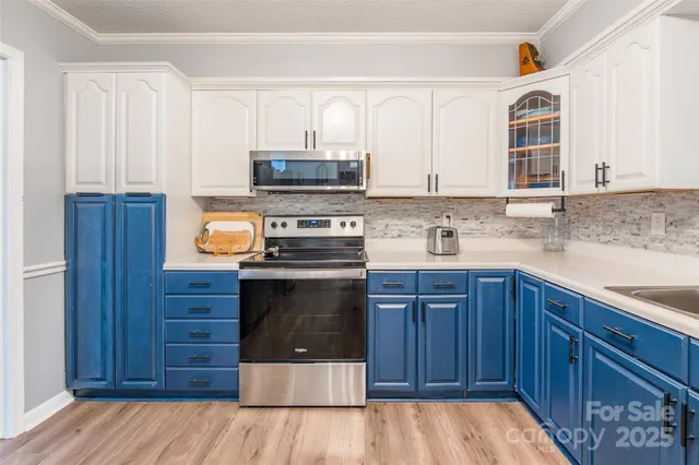 a kitchen with stainless steel appliances a stove a sink and a microwave