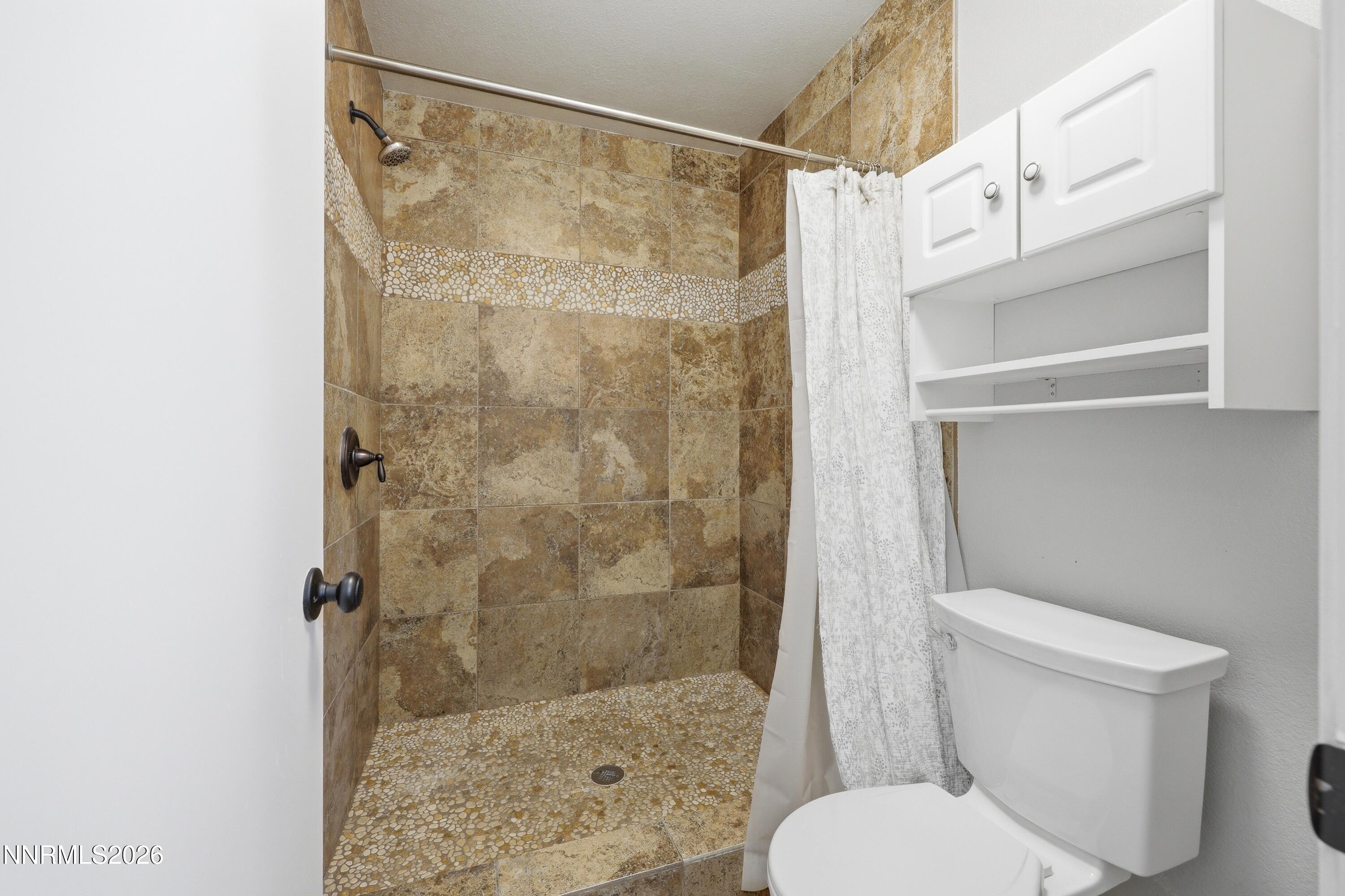 1899 Tuolumne Drive Reno, NV 89523 - Photo 23 of 44 a white toilet sitting next to a bathroom shower