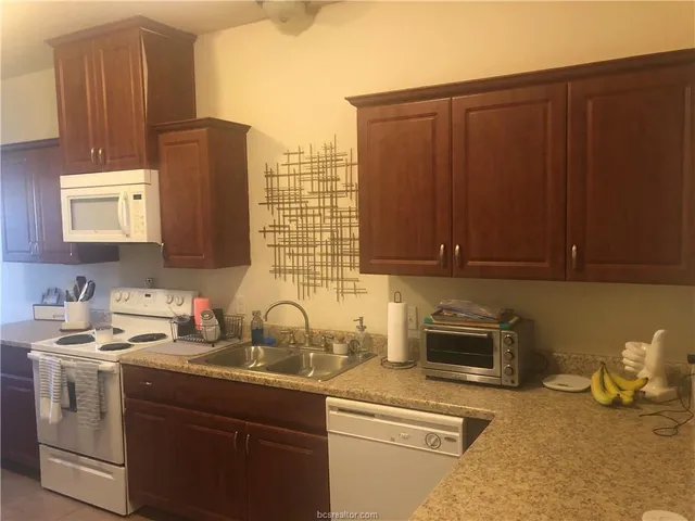 a kitchen with sink cabinets and appliances
