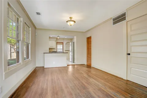 a view of a kitchen with a fridge wooden floor and a window