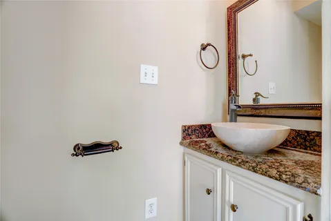 a bathroom with a granite countertop sink and mirror