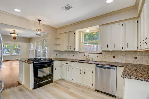 a kitchen with a stove sink and cabinets