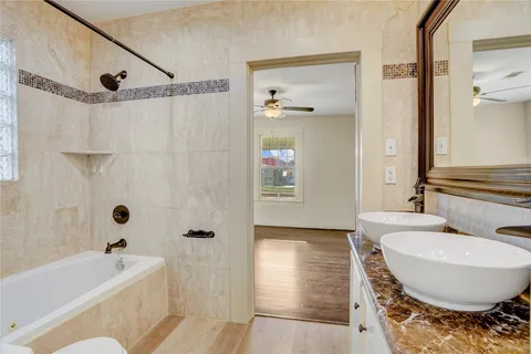 a bathroom with a tub toilet sink and mirror