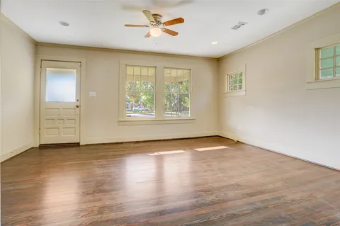 a view of an empty room with a window and wooden floor