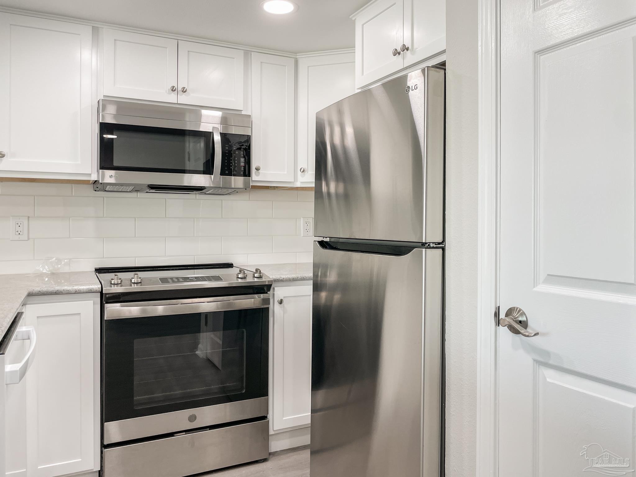 7200 Sharp Reef, Unit 2 Pensacola, FL 32507 - Photo 11 of 24 a kitchen with a stove microwave and refrigerator