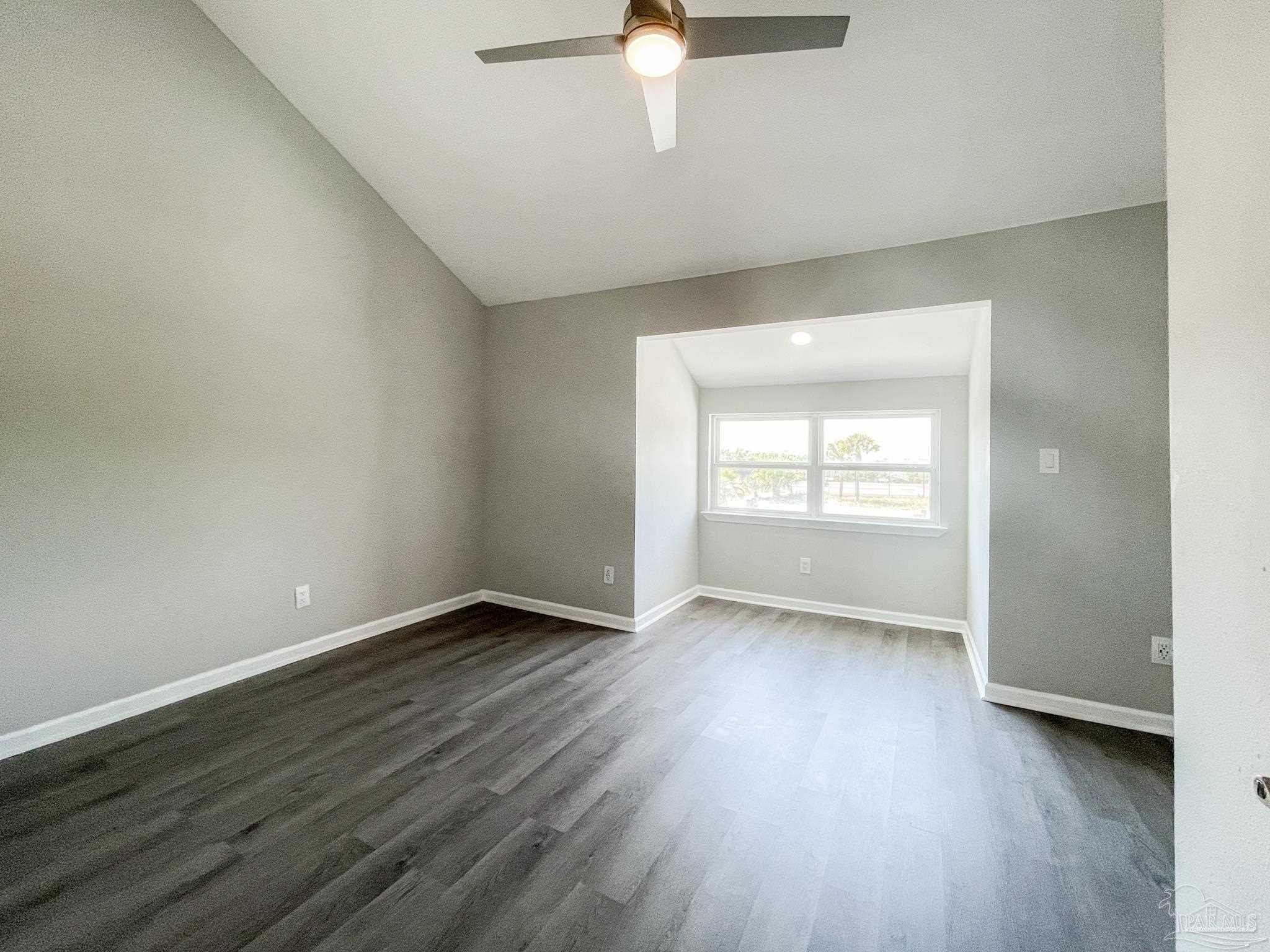 7200 Sharp Reef, Unit 2 Pensacola, FL 32507 - Photo 13 of 24 an empty room with wooden floor and windows