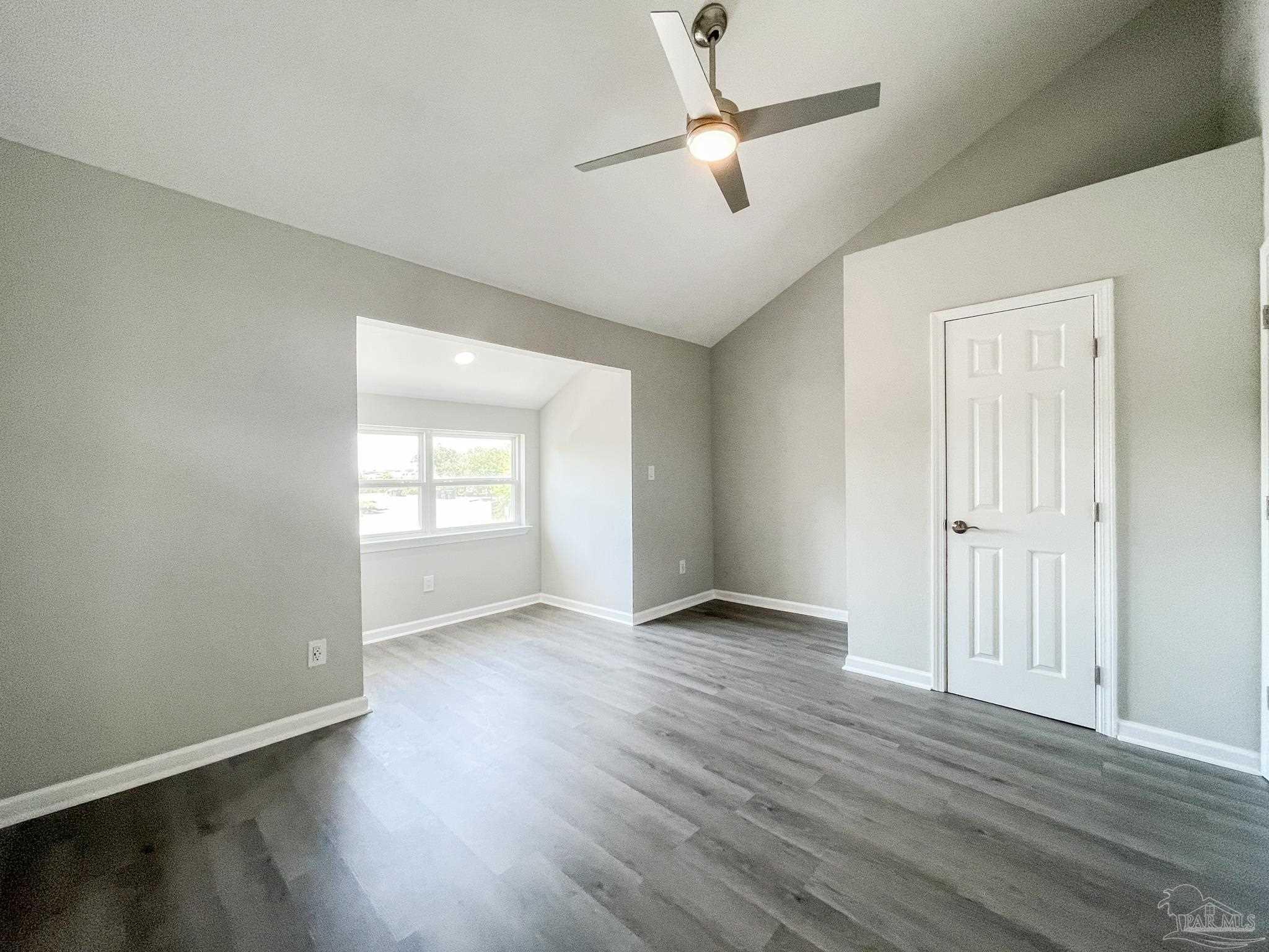 7200 Sharp Reef, Unit 2 Pensacola, FL 32507 - Photo 14 of 24 an empty room with wooden floor ceiling fan and windows