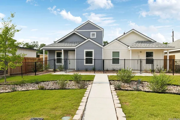 a front view of a house with a yard and potted plants