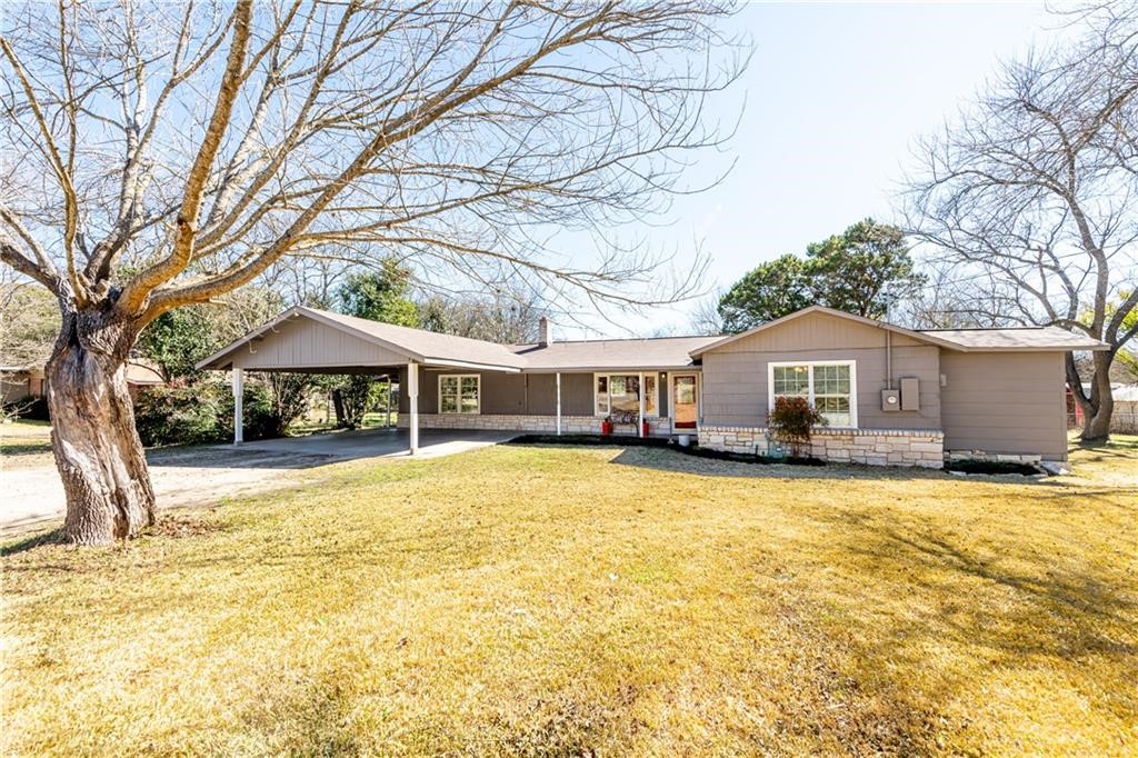 a front view of a house with yard and swimming pool