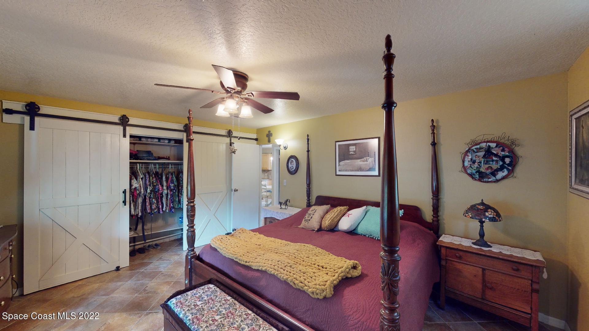 2005 Cox Road Cocoa, FL 32926 - Photo 20 of 35 a bedroom with a bed and a chandelier