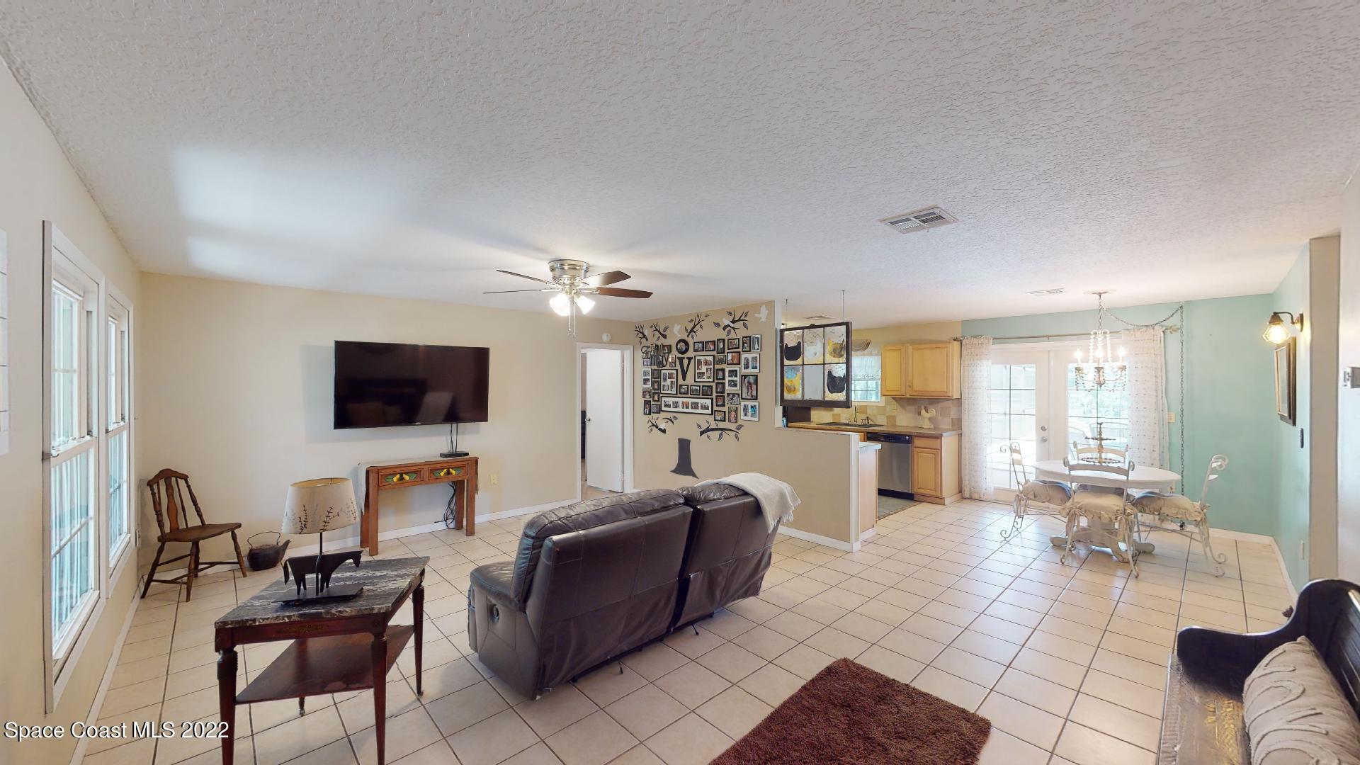2005 Cox Road Cocoa, FL 32926 - Photo 26 of 35 a living room with furniture a flat screen tv and a large window