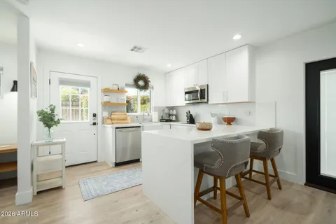 a kitchen with white cabinets and white appliances