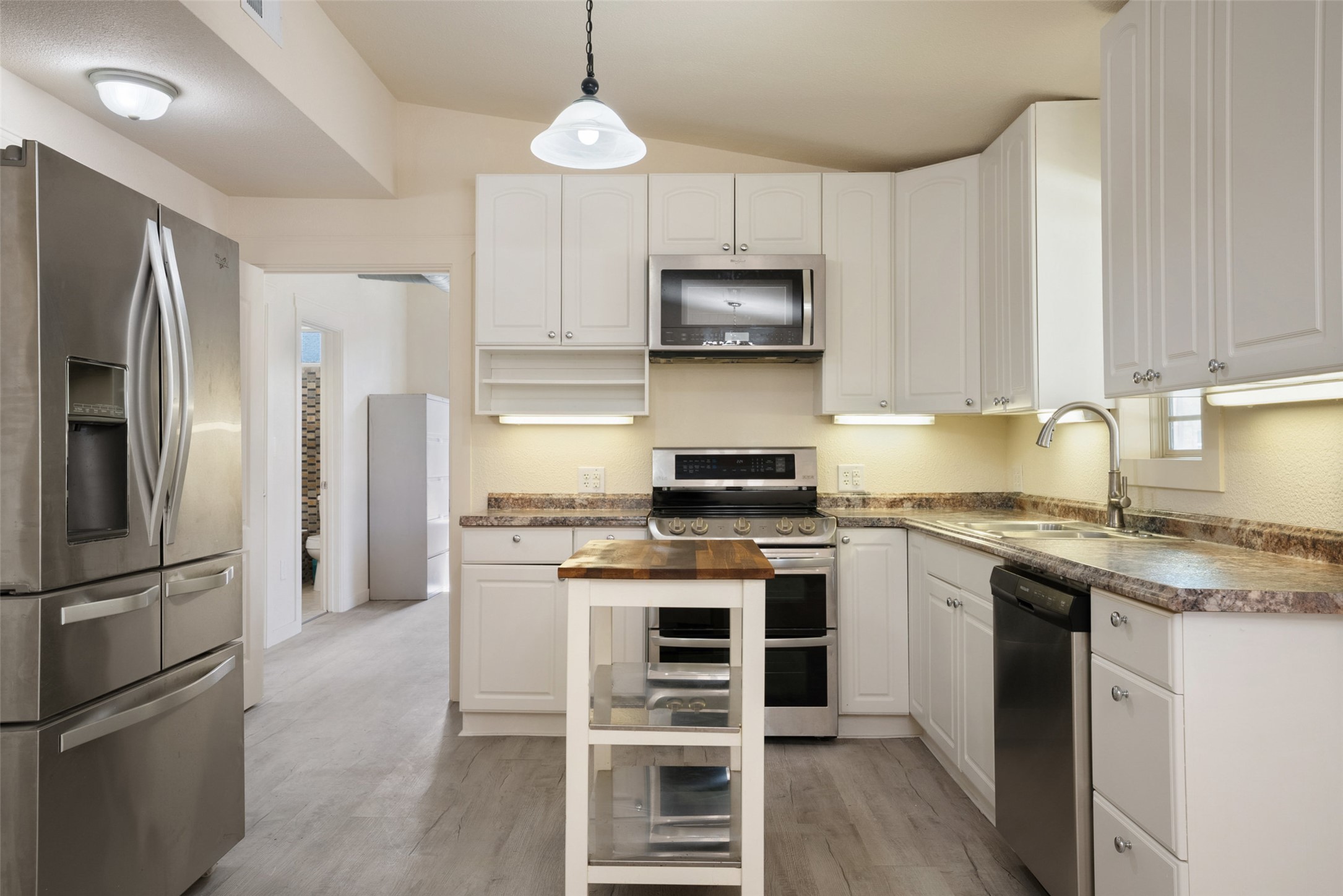 15303 Faubion Trail Leander, TX 78641 - Photo 30 of 39 a kitchen with stainless steel appliances a stove a sink and a refrigerator