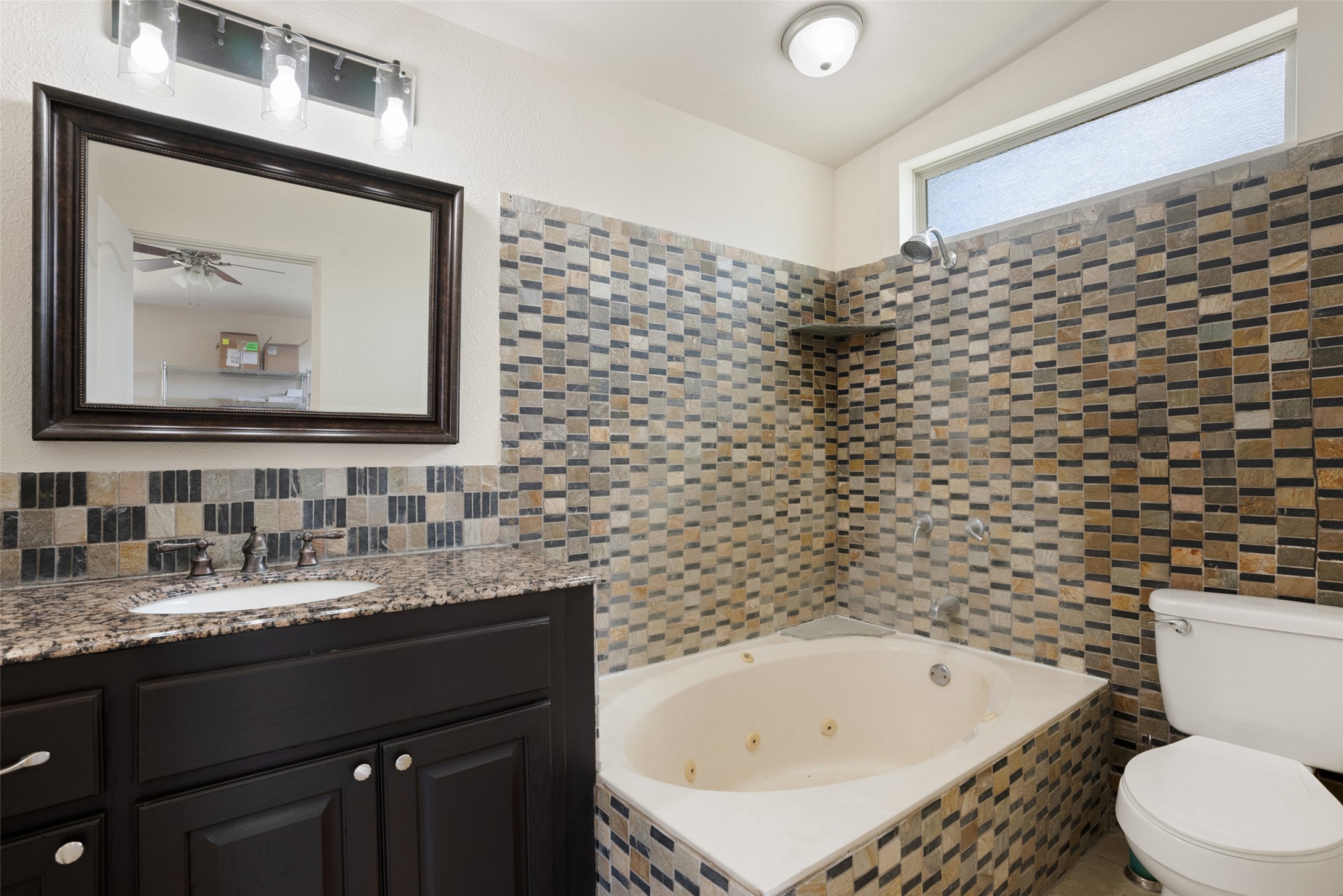 15303 Faubion Trail Leander, TX 78641 - Photo 33 of 39 a bathroom with a bathtub sink vanity mirror and toilet