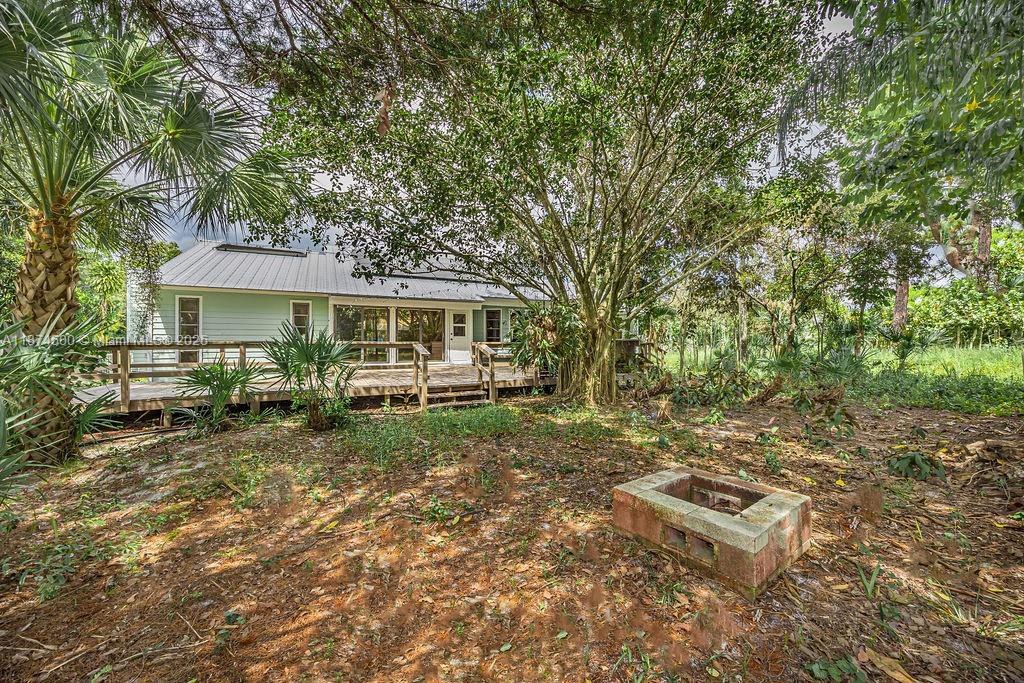 4882 Southeast Bayshore Terrace Stuart, FL 34997 - Photo 12 of 56 a backyard of a house with table and chairs