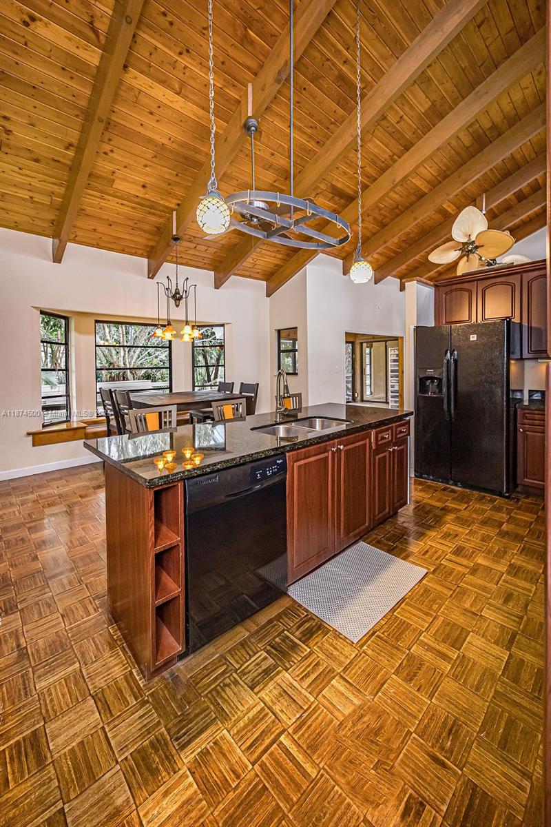4882 Southeast Bayshore Terrace Stuart, FL 34997 - Photo 28 of 56 a kitchen with stainless steel appliances kitchen island granite countertop a sink cabinets and wooden floor