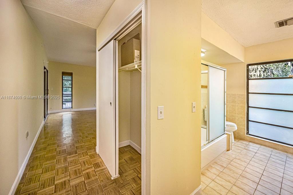 4882 Southeast Bayshore Terrace Stuart, FL 34997 - Photo 33 of 56 a view of a hallway with wooden floor and a bathroom