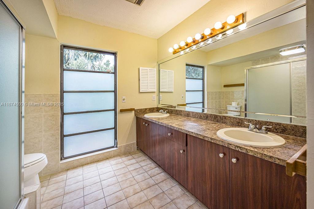 4882 Southeast Bayshore Terrace Stuart, FL 34997 - Photo 37 of 56 a bathroom with a granite countertop sink and a mirror