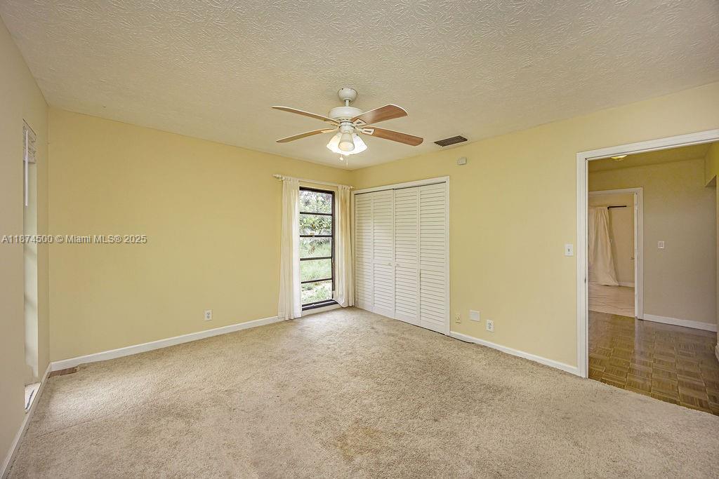 4882 Southeast Bayshore Terrace Stuart, FL 34997 - Photo 41 of 56 an empty room with closet and a ceiling fan
