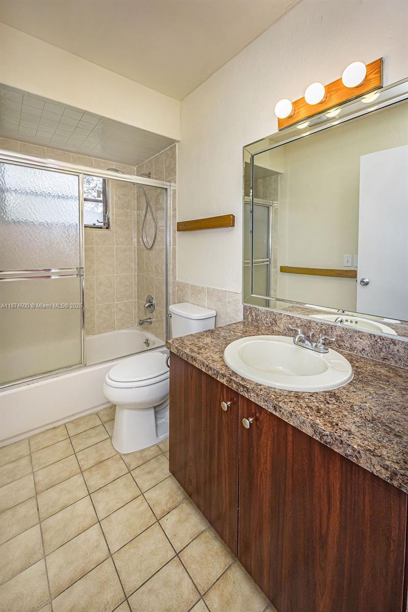 4882 Southeast Bayshore Terrace Stuart, FL 34997 - Photo 43 of 56 a bathroom with a granite countertop sink toilet and shower