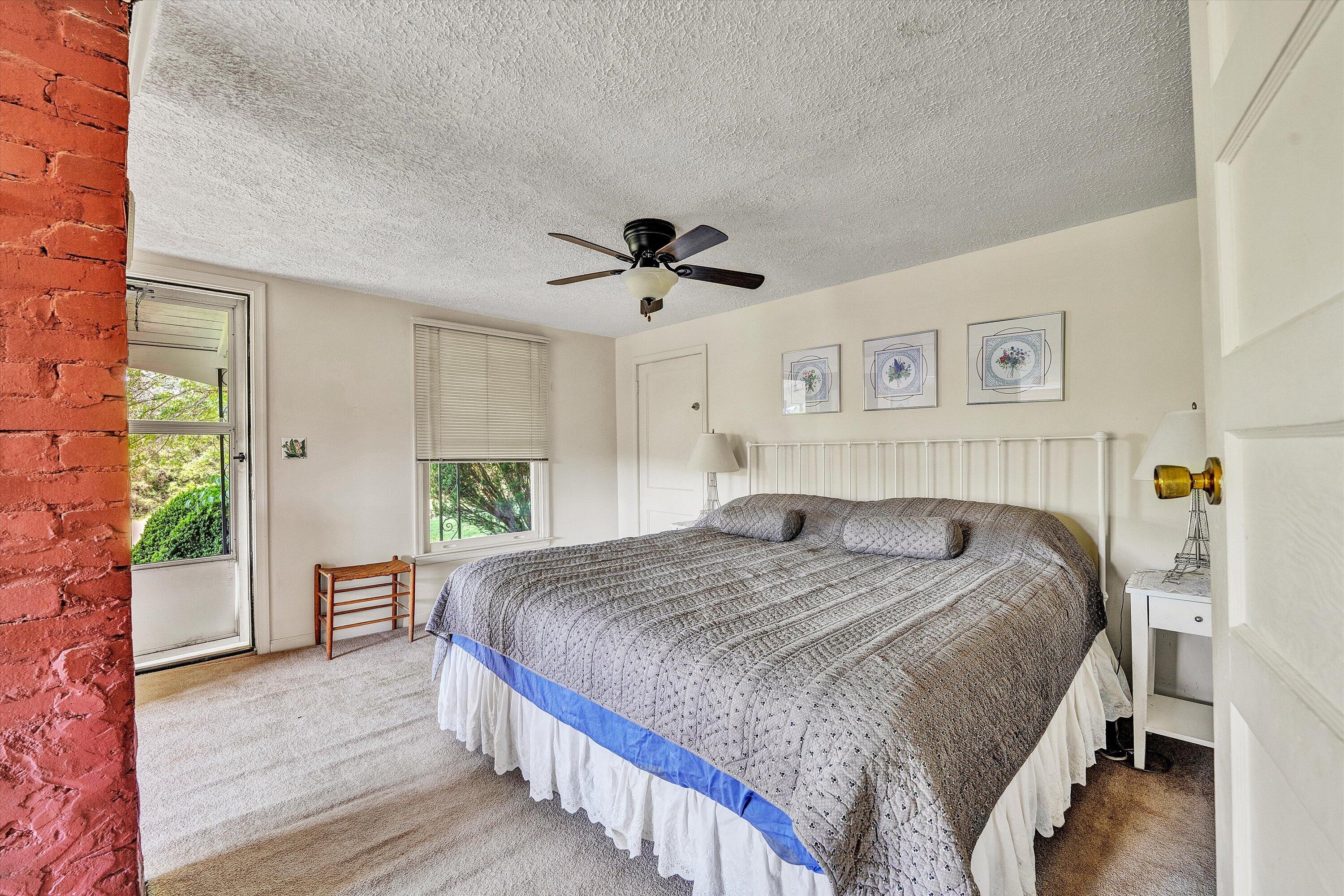 5328 White House Road Moneta, VA 24121 - Photo 13 of 39 a spacious bedroom with a bed and a chandelier