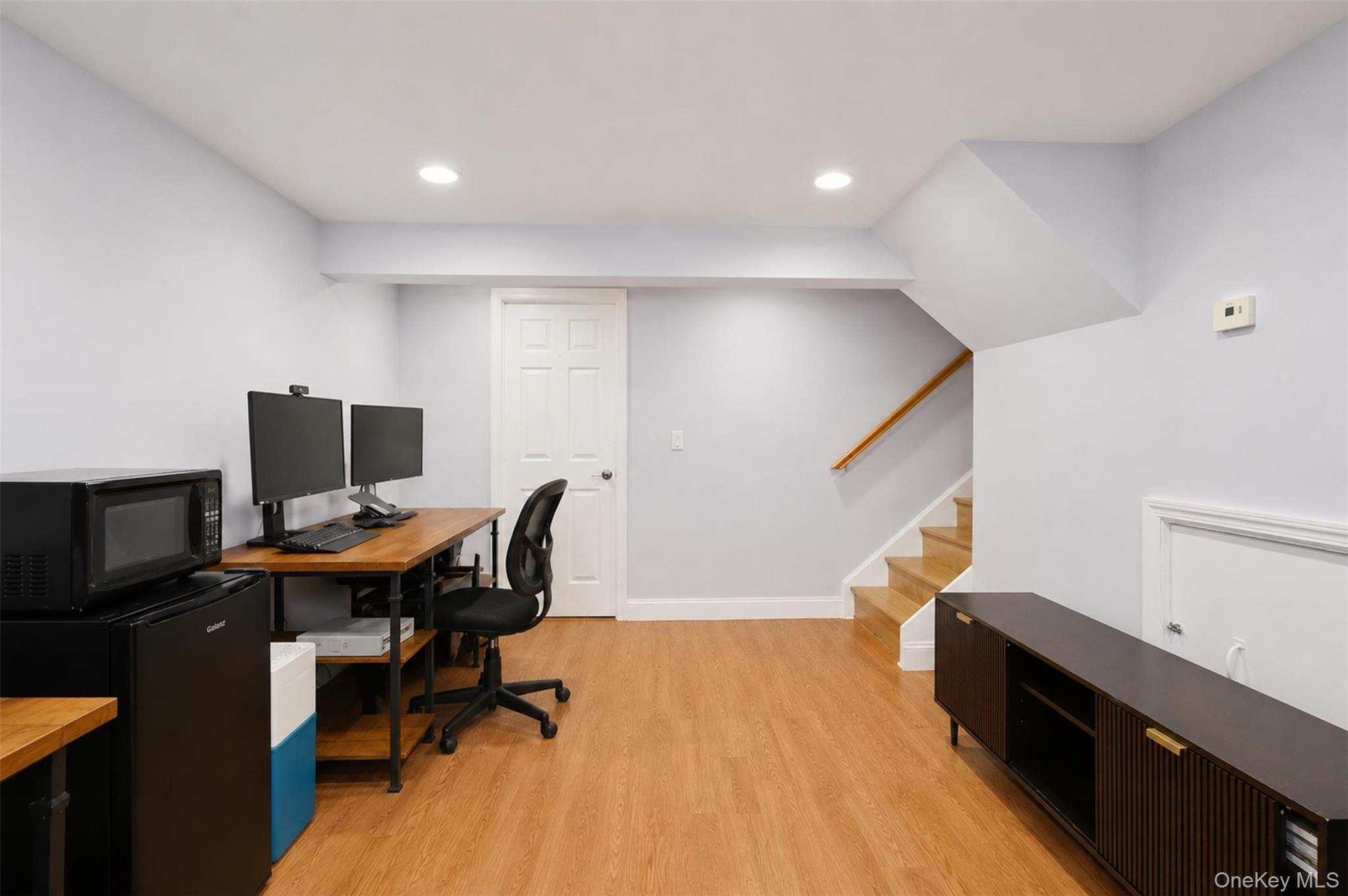 617 Cardinal Road Cortlandt Manor, NY 10567 - Photo 21 of 32 Versatile open space featuring wood-finish flooring, recessed lighting, a built-in staircase with wood handrail, and a white paneled door