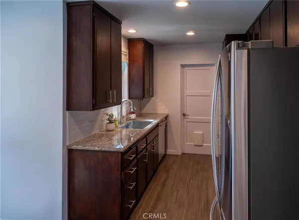 a bathroom with a granite countertop sink a mirror and a shower