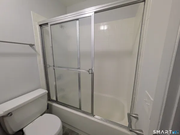 a bathroom with a toilet and a shower