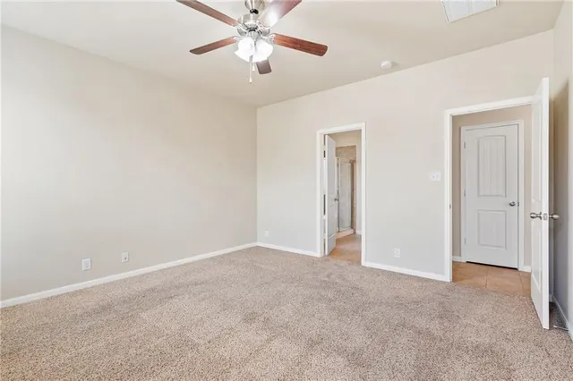 an empty room with closet and a chandelier fan