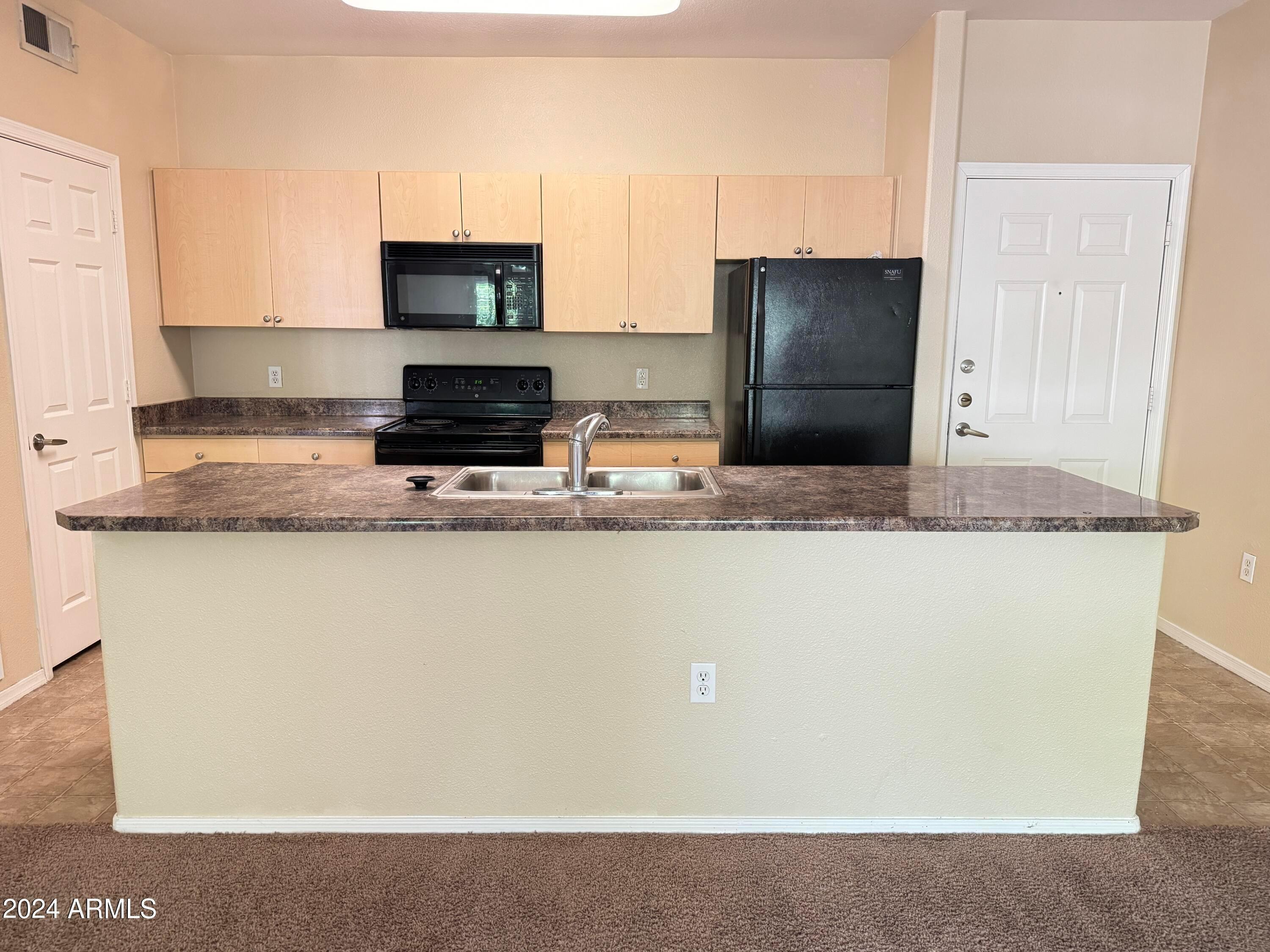 18416 North Cave Creek Road, Unit 2027 Phoenix, AZ 85032 - Photo 3 of 5 a kitchen with granite countertop a refrigerator and a stove
