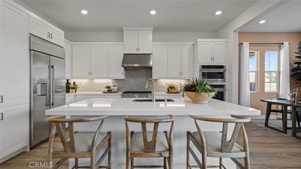 180 Sunrise Road Rancho Mission Viejo, CA 92694 - Photo 1 of 1 a kitchen with stainless steel appliances granite countertop a table chairs refrigerator and microwave