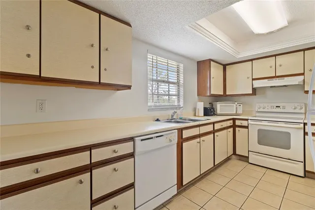 a kitchen with granite countertop white cabinets and white appliances