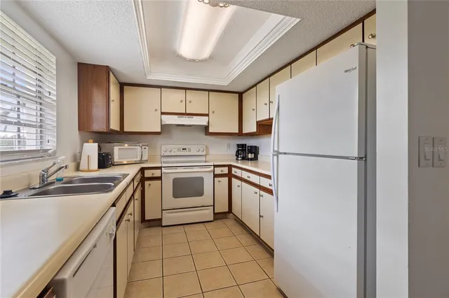 a kitchen with cabinets appliances a sink and a window