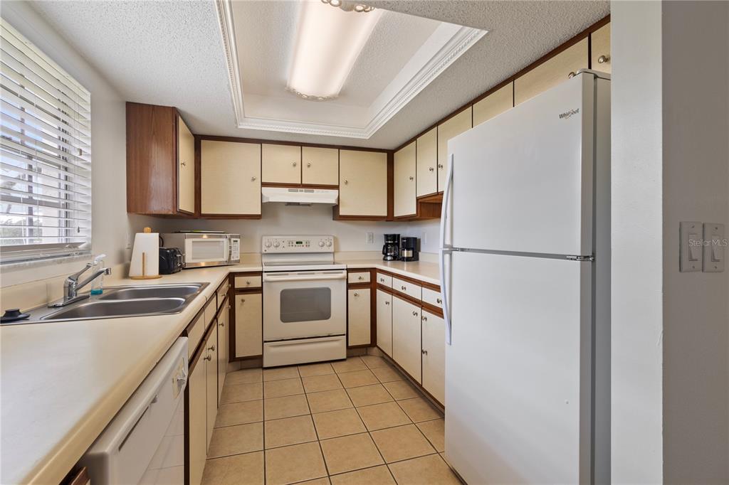 1531 Placida Road, Unit 203 Englewood, FL 34223 - Photo 12 of 28 a kitchen with cabinets appliances a sink and a window