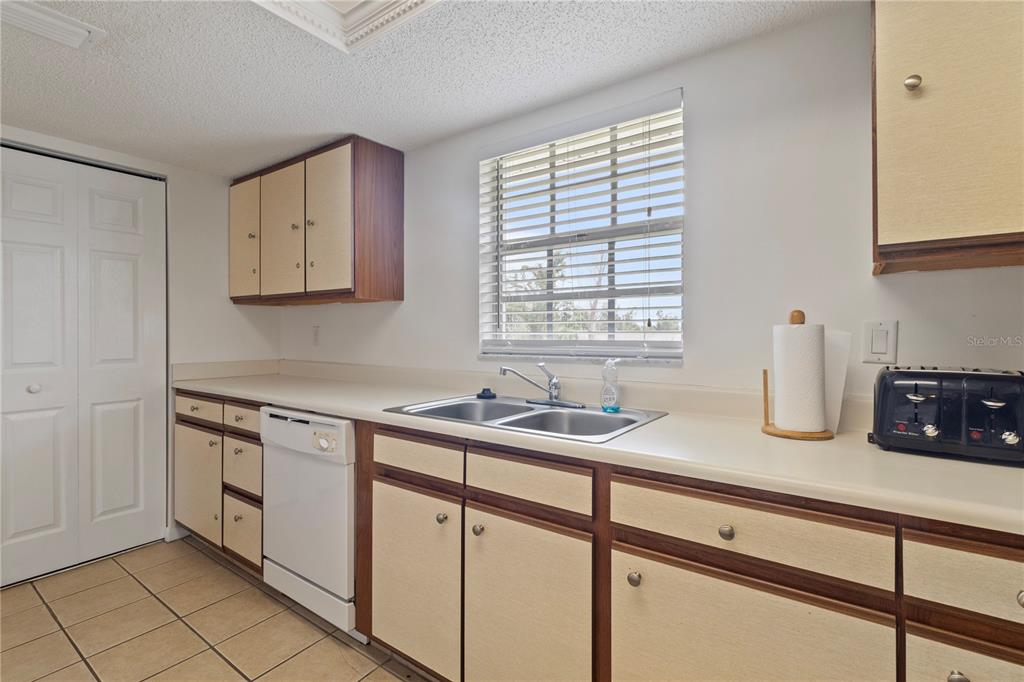 1531 Placida Road, Unit 203 Englewood, FL 34223 - Photo 14 of 28 a kitchen with stainless steel appliances granite countertop a sink and a white cabinets