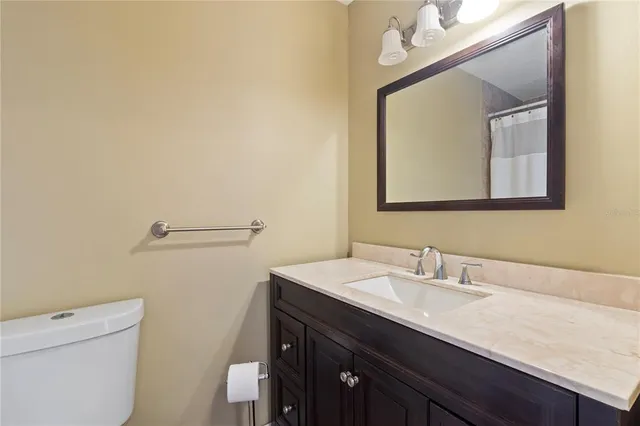 a bathroom with a sink vanity and a toilet