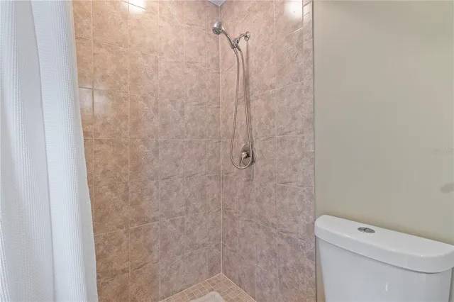 a white toilet sitting next to a shower
