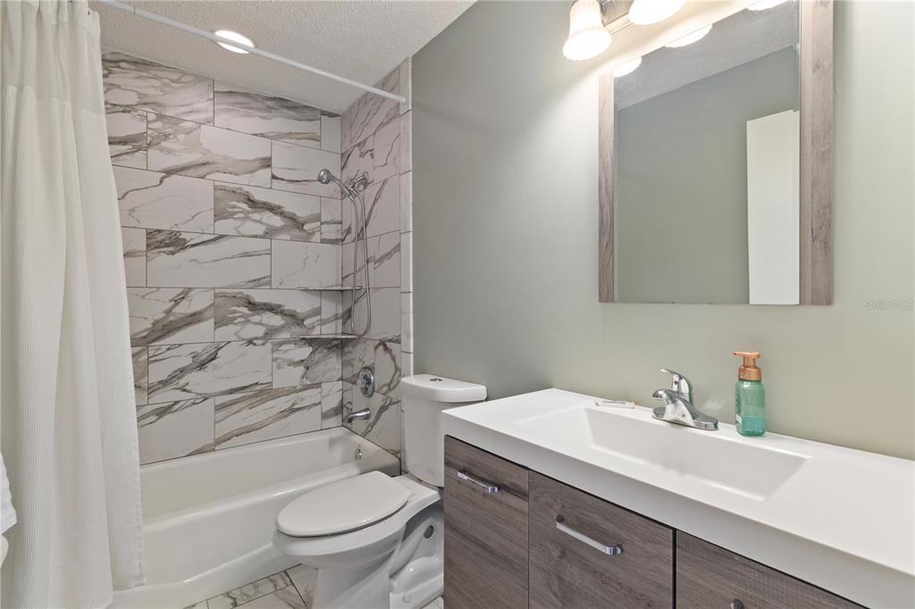 1531 Placida Road, Unit 203 Englewood, FL 34223 - Photo 21 of 28 a bathroom with a sink a toilet and shower