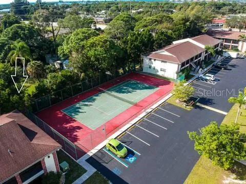 an aerial view of a tennis ground and a yard