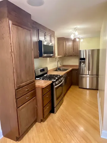 a kitchen with granite countertop stainless steel appliances and wooden cabinets
