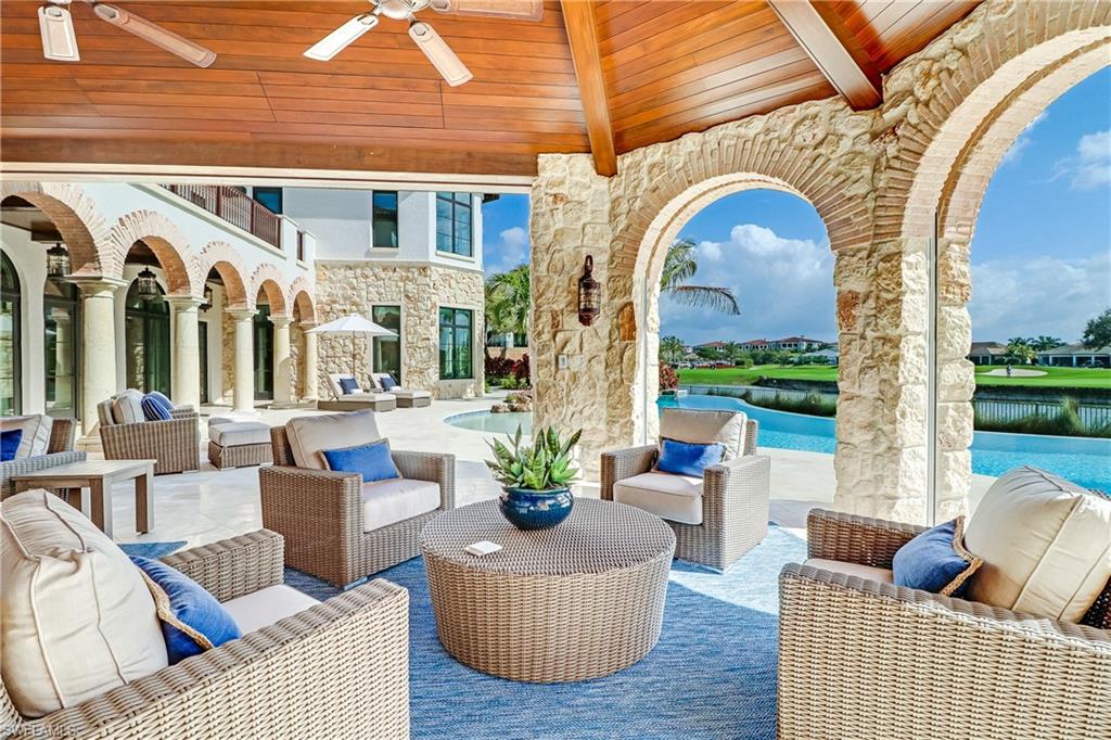 16622 Firenze Way Naples, FL 34110 - Photo 13 of 35 a living room with furniture and a floor to ceiling window