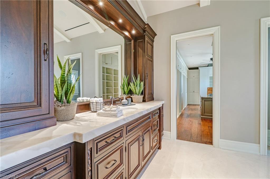 16622 Firenze Way Naples, FL 34110 - Photo 21 of 35 a bathroom with a sink a mirror and next to a window