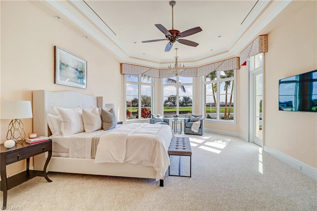 16622 Firenze Way Naples, FL 34110 - Photo 24 of 35 a spacious bedroom with a bed a chandelier and large window