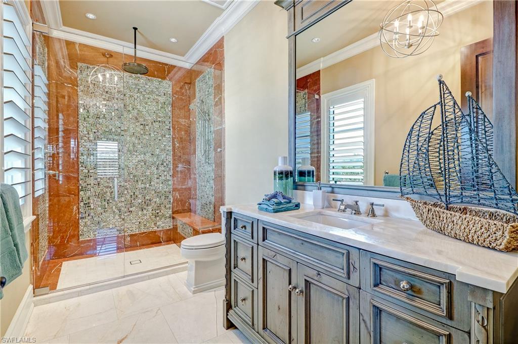 16622 Firenze Way Naples, FL 34110 - Photo 26 of 35 a bathroom with a granite countertop sink a toilet a mirror a bathtub and next to a window