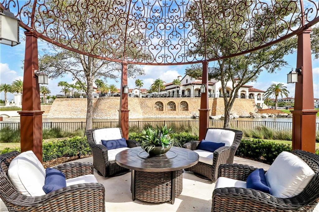 16622 Firenze Way Naples, FL 34110 - Photo 30 of 35 a view of a porch with furniture and a fire pit