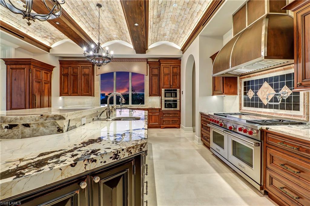 16622 Firenze Way Naples, FL 34110 - Photo 10 of 35 a kitchen with stainless steel appliances granite countertop a stove and a sink