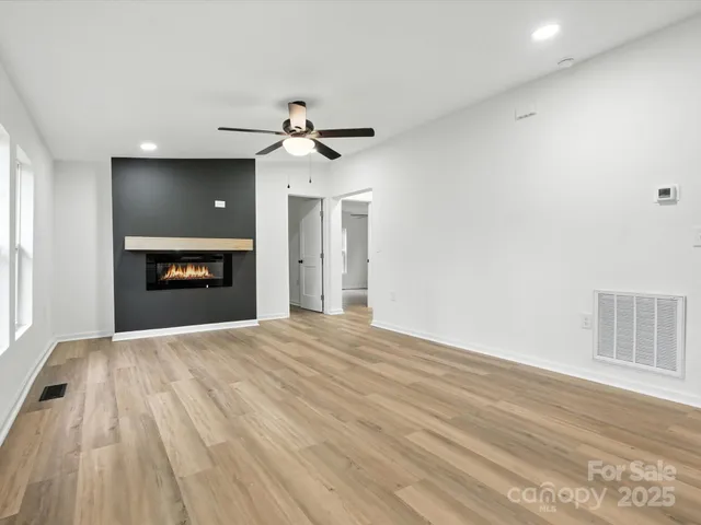 a view of an empty room with a fireplace and a window