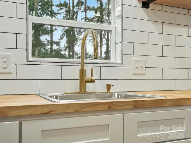 a bathroom with a granite countertop sink and a window
