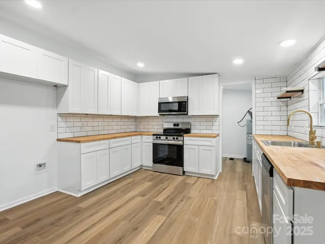 a kitchen with a refrigerator stove top oven and sink