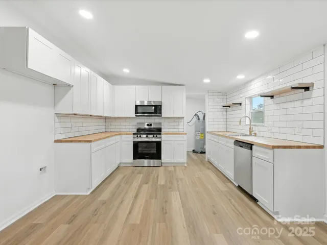 a kitchen with white cabinets and white appliances